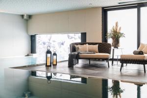 ein Wohnzimmer mit einem Sofa und einem Glastisch in der Unterkunft Arpuria l hidden luxury mountain home - ADULTS FRIENDLY in Sankt Anton am Arlberg