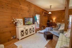 ein Wohnzimmer mit Fernseher und Holzwänden in der Unterkunft Happy Apple in Blowing Rock
