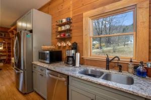 eine Küche mit Spüle und Kühlschrank in der Unterkunft Happy Apple in Blowing Rock