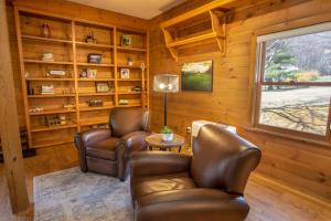 ein Wohnzimmer mit zwei Ledersesseln und einem Tisch in der Unterkunft Happy Apple in Blowing Rock