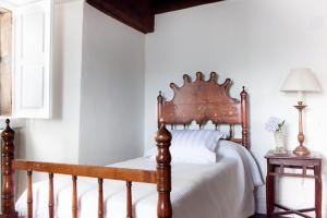 1 cama con cabecero de madera en un dormitorio en Casona Puerto de Vega, en Puerto de Vega