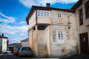 a house with a white door on a street at Casona Puerto de Vega in Puerto de Vega