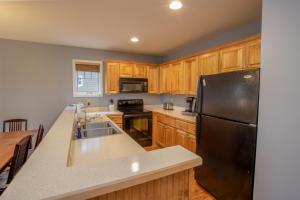 a kitchen with wooden cabinets and a black refrigerator at Havens Rest in Valle Crucis +10 photos
