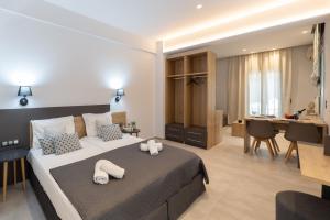 a bedroom with a bed and a desk in a room at Petani beach suites in Vovikes