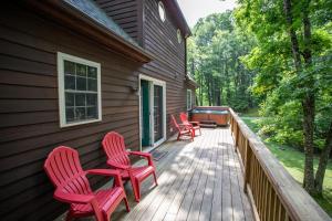 four red chairs on a porch of a house at Hidden Hawk in Seven Devils