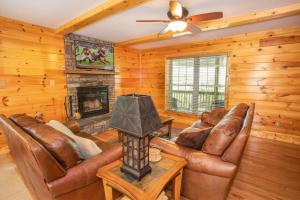 a living room with leather furniture and a fireplace at Hidden Hawk in Seven Devils