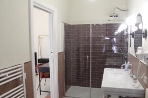 a bathroom with a glass shower and a sink at Sant'Agostino - Luxury Rooms in Messina