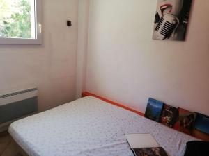 a small bedroom with a bed with a laptop on it at Appartement La Rochelle, 2 pièces, 4 personnes - FR-1-246-555 in La Rochelle