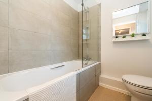 a bathroom with a tub and a toilet and a sink at Chic 3BR House in Hull - sleeps 5 in Hull