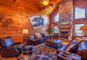a living room with leather furniture and a fireplace at Hilltop Haven in Boone