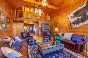 a living room with leather furniture in a log cabin at Hilltop Haven in Boone