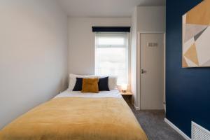 a large bed in a room with a blue wall at Chic 3BR House in Hull - sleeps 5 in Hull