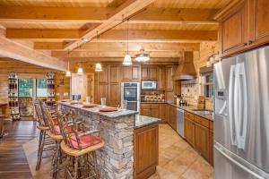 una cocina con encimera de piedra y armarios de madera en Lake Haven Lodge, en Wilkesboro