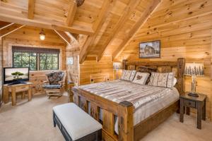 una camera da letto in una baita di tronchi con letto e scrivania di Lake Haven Lodge a Wilkesboro
