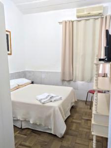 1 dormitorio con 1 cama blanca y ventana en Casa da vó, en São Gabriel