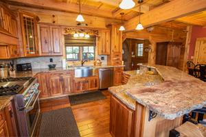 duża kuchnia z drewnianymi szafkami i granitowymi blatami w obiekcie Malone Bay On Kerr Scott Lake w mieście Wilkesboro