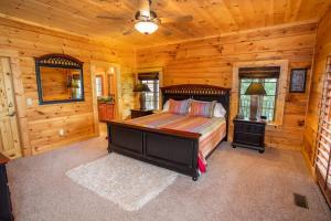 a bedroom of a cabin with a bed and a ceiling fan at Malone Bay On Kerr Scott Lake in Wilkesboro