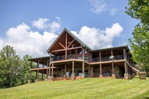 duży drewniany dom na trawiastym wzgórzu w obiekcie Malone Bay On Kerr Scott Lake w mieście Wilkesboro