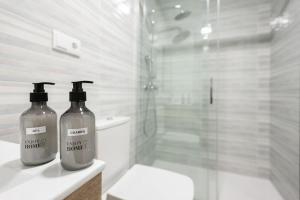 twee flessen wasmiddel op een aanrecht in een badkamer bij Apartamento Frida centro Gijón in Gijón