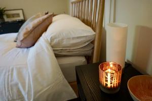 um quarto com uma cama e uma vela sobre uma mesa em Yoku House em Bournemouth