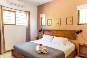 a bedroom with a bed with two towels at Nautilus Surf & Yoga Villas Santa Teresa in Santa Teresa Beach