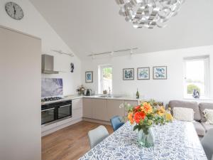 een keuken en een woonkamer met een tafel met een vaas met bloemen bij Blue Neptune in Lyme Regis