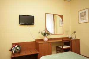 a room with a desk with a mirror and a television at Hotel Ezzelino in San Zenone