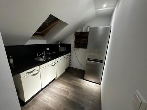 a kitchen with a stainless steel refrigerator and wooden floors at Max in Dernbach