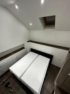 a small room with a white bed in it at Max in Dernbach