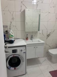 bagno bianco con lavatrice e lavandino di Eviniz gibi Hijyenik Rahat Edebileceğiniz Daire a Istanbul
