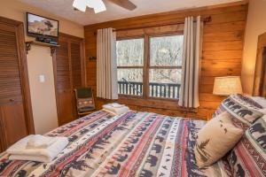 una camera da letto con un letto grande e una finestra di Mountain Skye Lodge a Banner Elk