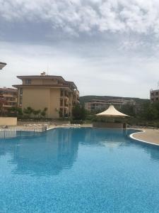 a large blue swimming pool in front of a building at Sveti Vlas Sky Dreams Apartment in Sveti Vlas