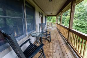 a porch with two chairs and a table on it at Mountain Melody in Blowing Rock