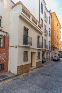 um edifício branco com varandas numa rua em La Casita del Mercado em Málaga