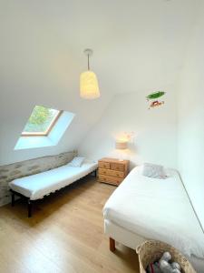 Schlafzimmer mit einem Bett, einer Bank und einem Fenster in der Unterkunft Maison bord de mer ・La côtière・ in Piriac-sur-Mer