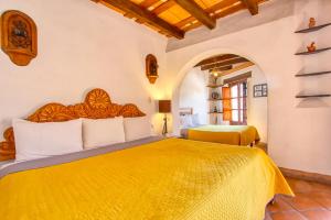 a bedroom with a large yellow bed in a room at Hotel Real Guanajuato in Guanajuato