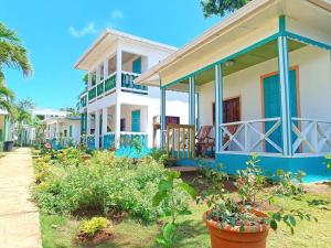 a large white house with blue accents at Los Delfines Hotel & Dive Center in Little Corn Island