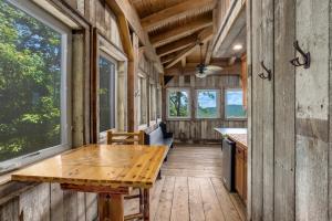 a dining room with a wooden table and windows at Renaissance Lodge in Blowing Rock