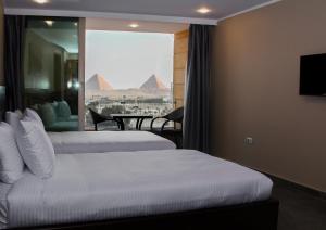 開羅的住宿－Asia Grand Museum & Pyramids view，酒店客房设有两张床,享有金字塔的景色。