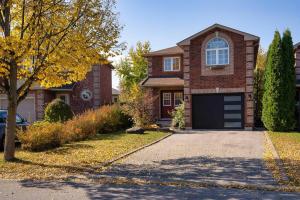 a brick house with a garage and a driveway at Adorable 1-bdrm basement, Fast WIFI, Free Parking, Smart TV in Barrie