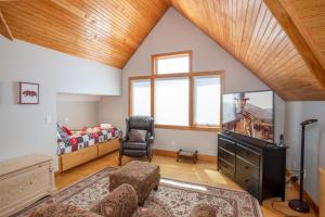 a living room with a bed and a couch and a television at Snow Dog Lodge in Beech Mountain