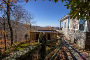 a house on a hill with a fence next to it at Snow Dog Lodge in Beech Mountain
