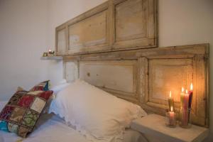 - un lit avec une tête de lit en bois et deux bougies dans l'établissement Signora Minù Bilocale Semindipendente, à Lecce