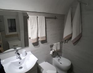 La salle de bains blanche est pourvue d'un lavabo et de toilettes. dans l'établissement Signora Minù Bilocale Semindipendente, à Lecce