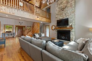 una sala de estar con sofás y una chimenea de piedra. en Stone Mountain Lodge, en Trade