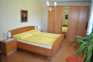 a bedroom with a bed with yellow sheets and a mirror at Am Randersberg - Wohnung Nr 3 in Grossgmain