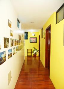 pasillo con paredes amarillas, suelo de madera y puerta en Hostal Bavaria de la Alameda, en Quito
