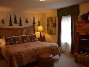 um quarto com uma cama e uma janela com árvores na parede em The Bavarian Manor Hotel em Purling