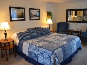 um quarto com uma cama com um cobertor azul e branco em The Bavarian Manor Hotel em Purling