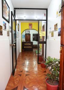un pasillo con una puerta abierta a una habitación de hotel en Hostal Bavaria de la Alameda, en Quito
